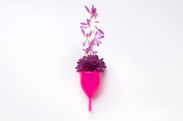 Photo menstrual cup with flowers on white