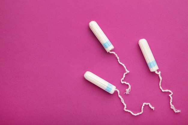 Menstrual tampon on a pink background. Cotton tampon for women. Top view