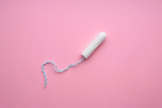 Menstrual tampon on a pink background. Hygiene and protection.