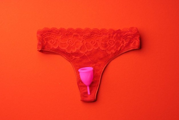 Menstruatiecup en slipje op papier achtergrond