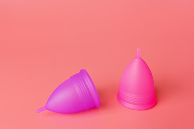 Menstruatiecups op roze achtergrond. Alternatief product voor vrouwelijke hygiëne tijdens de periode.