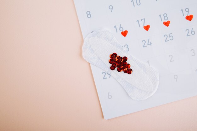 Menstruatiekalender met dagelijkse maandverband op roze achtergrond. vrouw kritische dagen, vrouw hygiëne bescherming concept.