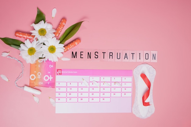 Menstruatiekalender met katoenen tampons, maandverband, witte bloem. Kritieke dagen voor vrouwen, bescherming van vrouwenhygiëne