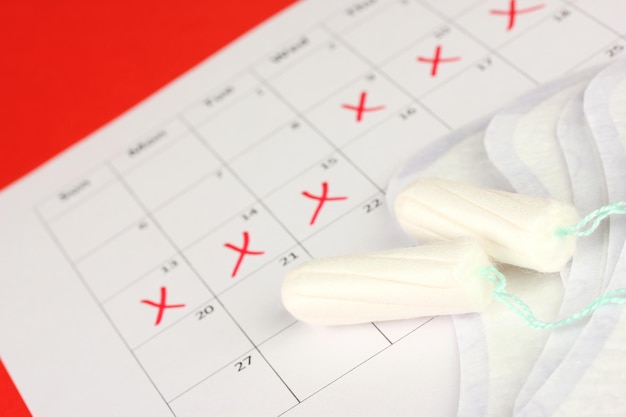 Menstruatiekalender met maandverband en tampons close-up