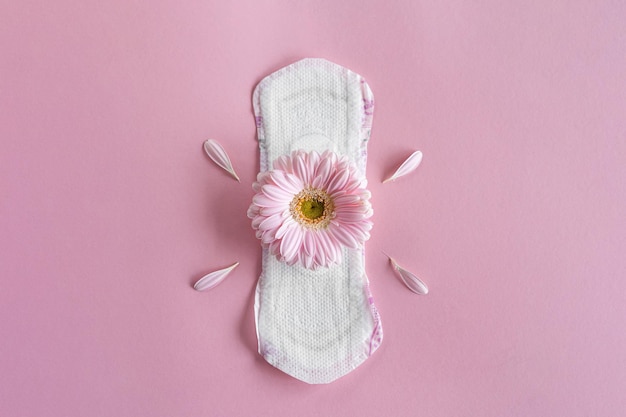 Menstruatieperiode concept Hygiënische witte vrouwelijke pad met gerberabloemen Menstruatiebescherming Gezondheid van vrouwen