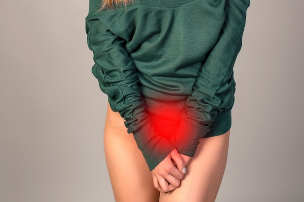 Foto menstruatiepijn vrouw met buikpijn die lijdt aan pms endometriose cystitis en andere ziekten van het urinewegstelsel pijnlijk gebied rood gemarkeerd