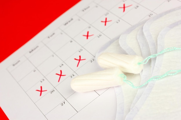 Menstruation calendar with sanitary pads and tampons closeup