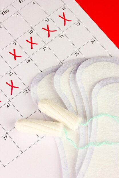 Foto calendario delle mestruazioni con assorbenti e tamponi in primo piano