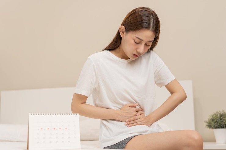 Photo 월경 주기의 날 복통을 앓고 있는 아시아 젊은 여성 여성은 집에서 pms 월경 전 배나 복통으로 고통 받고 있습니다. 건강 문제 신체의 염증