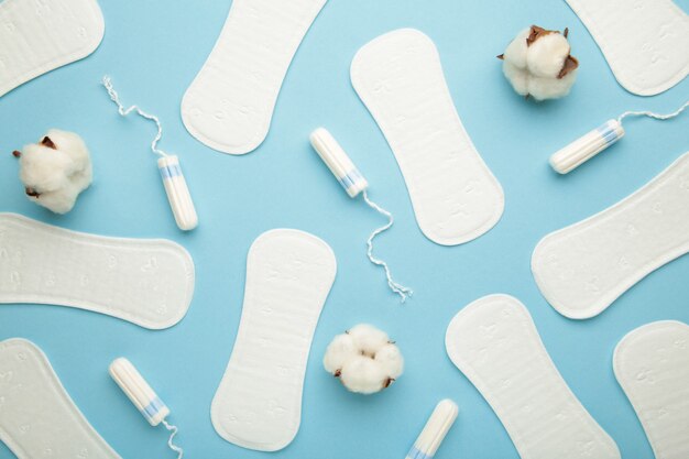 Menstruele tampons en pads op een blauwe achtergrond. Menstruatie cyclus. Hygiëne en bescherming. Bovenaanzicht.