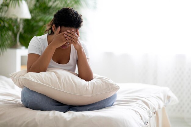 Mental breakdown portrait of upset young african american woman crying at home