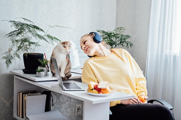 Mental health and work work life balance young woman in headphones near laptop at home office