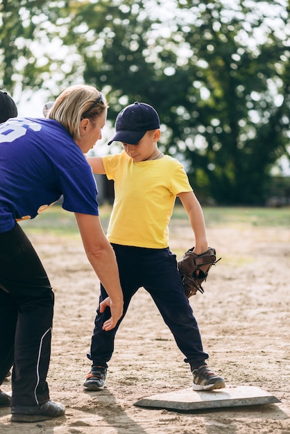 mentor shows the little boy how to stand properly while playing baseball