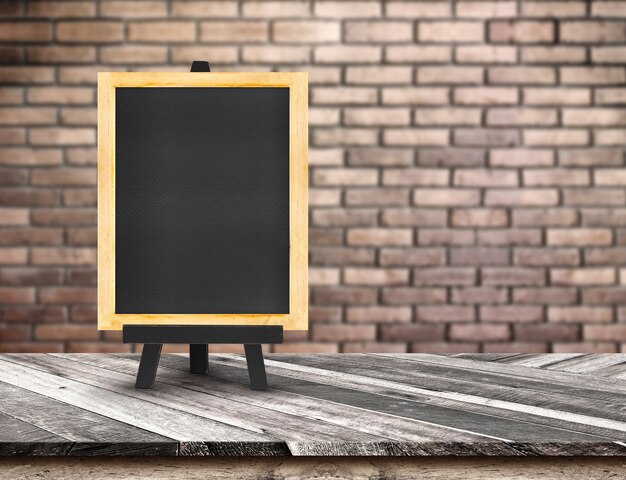 Photo menu blackboard on diagonal wooden table top at blurred red brick wall