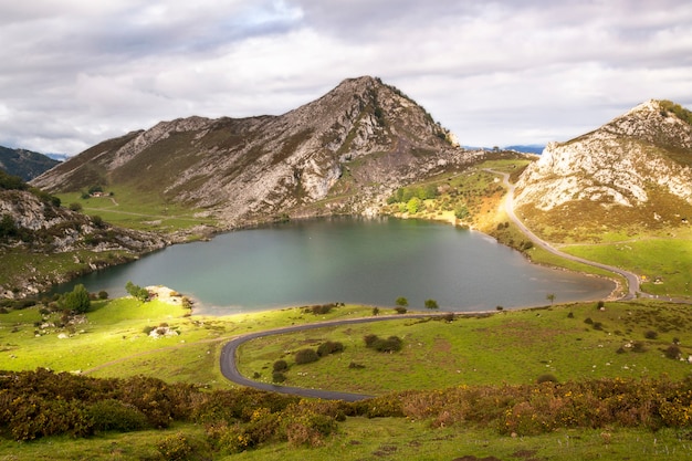 Meren van Covadonga met mist in het voorjaar. Toeristen wandelen op Lake Enol. Asturië, Spanje