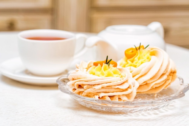 Meringue cake decorated with kumquat and tea