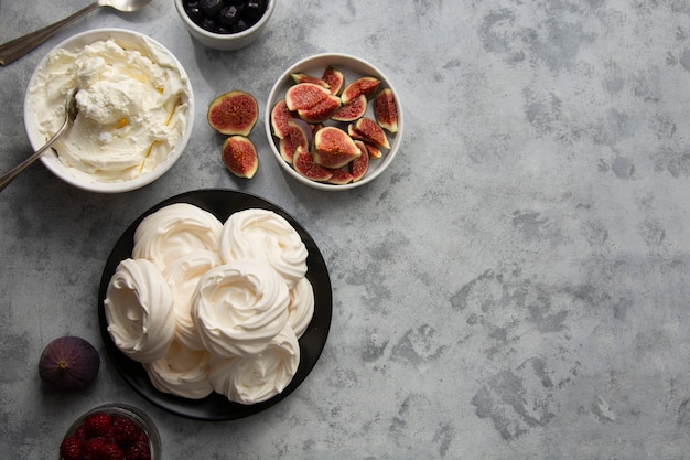 Meringue cakes decorated with berries and figs