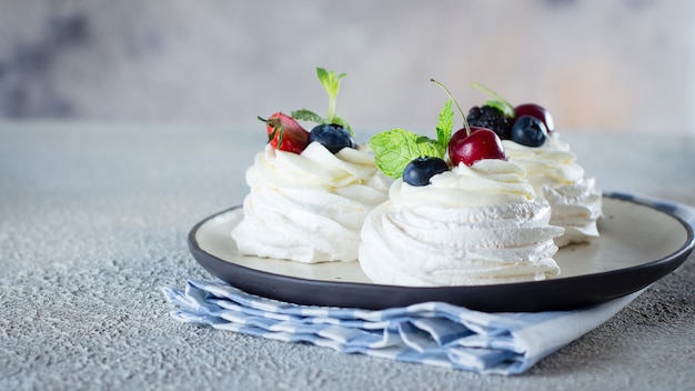 Безе десерт Павлова торт со свежими ягодами на тарелку.