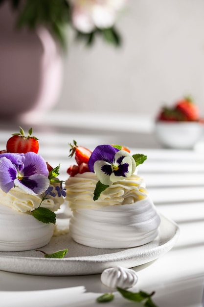 Meringue dessert with berries and flowers for breakfast