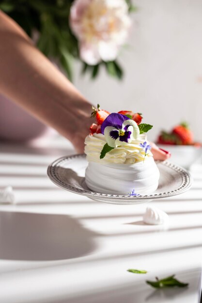 Meringue dessert with berries and flowers for breakfast