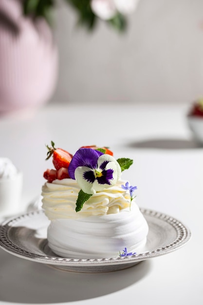 Photo meringue dessert with berries and flowers for breakfast