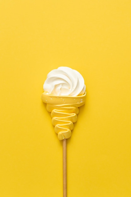 Meringue ice cream cone on yellow background