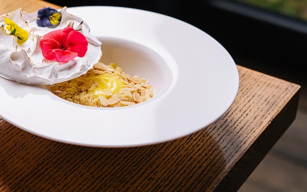 Meringue on plate and almonds with vanilla custard