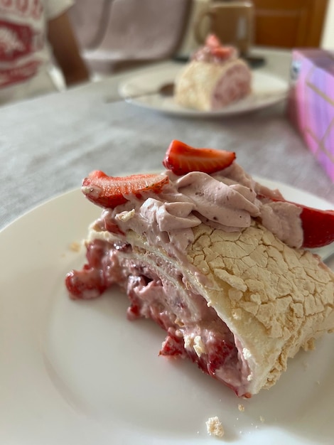 Meringue roll Pavlova cake met slagroom en verse aardbeien bovenop Roll cake