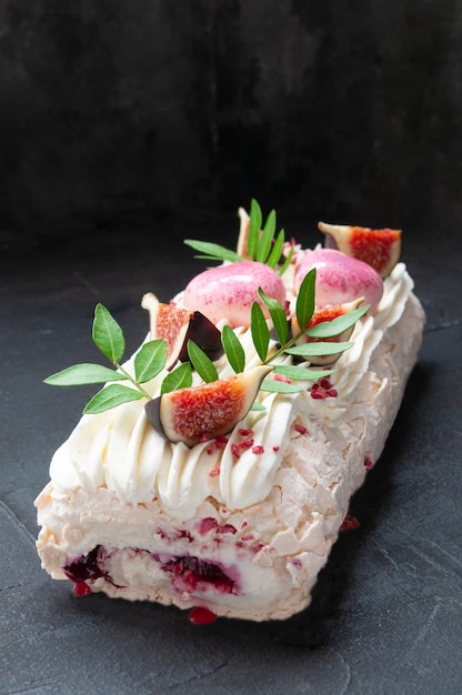 Rotolo di meringa con marmellata di ciliegie decorato con verdure e fettine di fichi fondo scuro