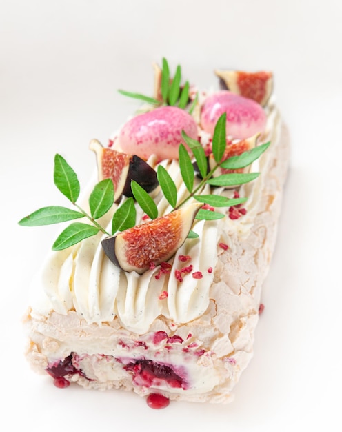 Meringue roll with cherry jam Decorated with greenery and fig slices Light background