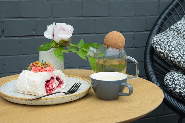 Meringue roll with a cup of buckwheat tea on a table in an outdoor cafe Sweet food Still life