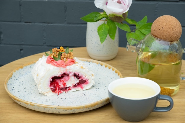 カフェのテーブルにお茶とメレンゲ ロール甘い食べ物の静物画