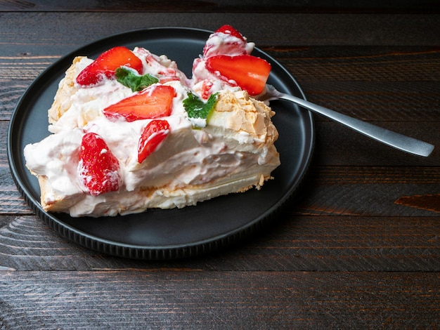 Meringue rollade Meringue roll cake Pavlova met room aardbeien en muntblaadjes Zijaanzicht