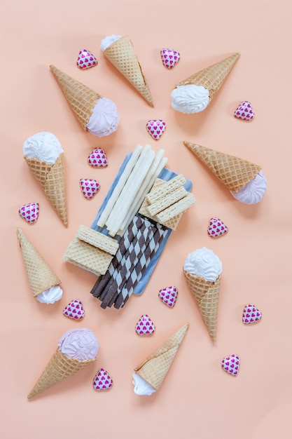 Meringue, variety Marshmallows, wafer rolls and waffles  charcuterie board on pink background. Close up, top view.