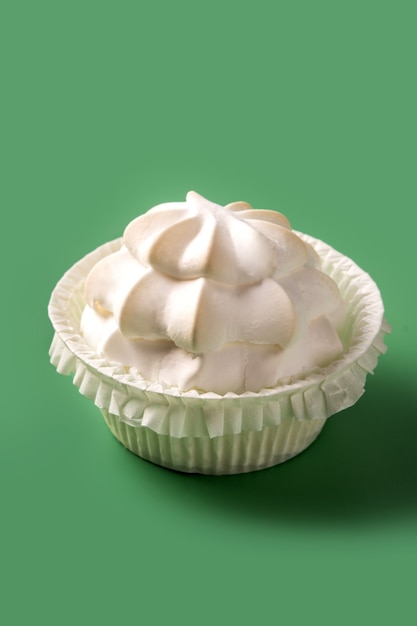 Meringue whipped cream on green background