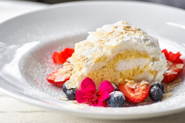 Meringuebroodje met aardbeien bosbessen frambozen en veenbessen Dessert gedecoreerd met verse bessen