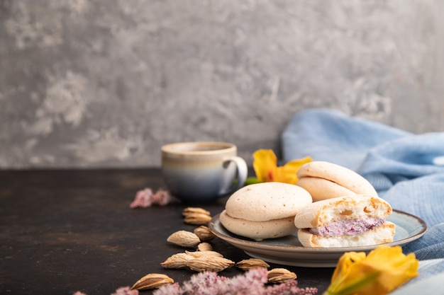 Meringhe torte con una tazza di caffè su una superficie di cemento nero e tessuto di lino blu