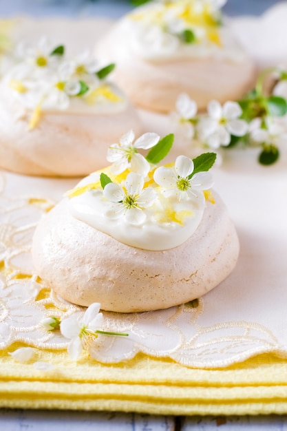 Meringues decorated with lemon zest and cherry blossom