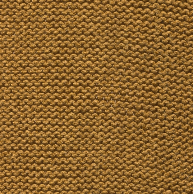 Merino mustard wool knit texture for the design Knitted woolen cotton fabric background in mustard color