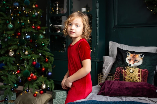 写真 メリー クリスマスと幸せな休日の女の子が朝のクリスマス ツリーの近くで楽しんで