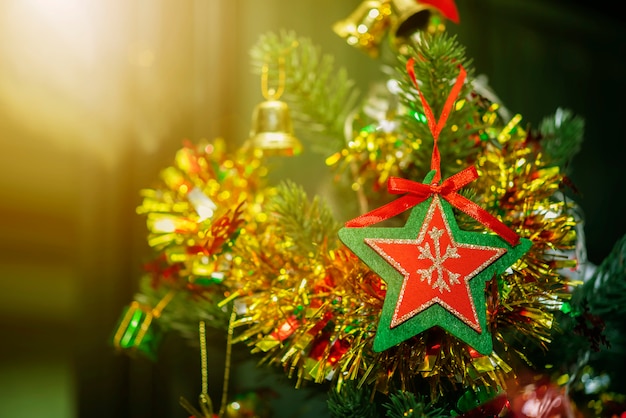 Концепция Рождества Рождества. Макрофотография красной звезды с зеленой рамкой висит на Христа