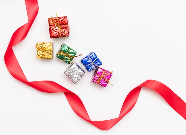 Веселая рождественская открытка из еловых веток, подарочные коробки, красные украшения, блестки и конфетти на белом фоне