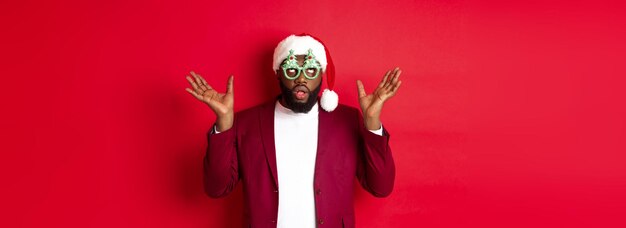 Photo merry christmas cheerful black man wearing funny party glasses and santa hat smiling joyful celebrat