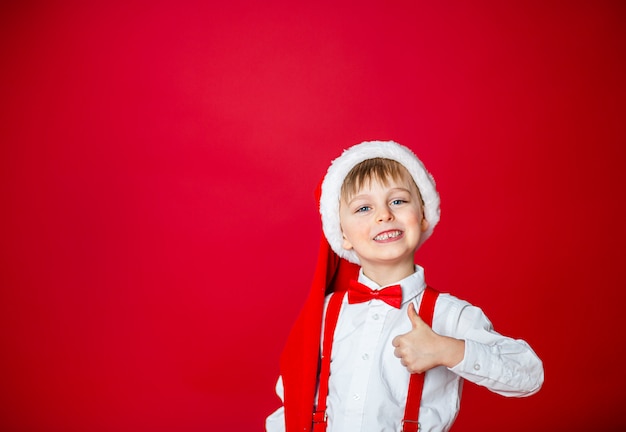 メリークリスマス。サンタクロースの帽子でかわいい陽気な男の子