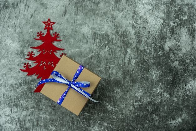 Merry Christmas decorations. Flat lay essential difference objects gift box & fir tree on modern cement