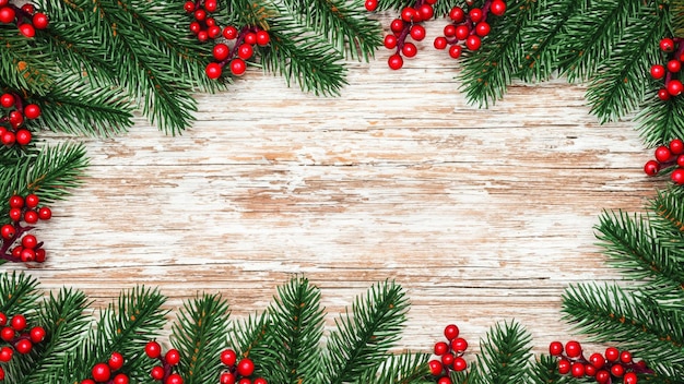 Merry Christmas Evergreen Branches and Berries Over Rustic Wooden Background Space for Text