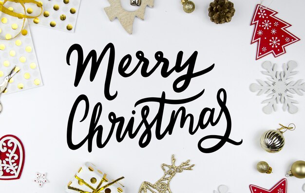 Photo merry christmas hand lettering greeting card. styled scene with christmas decorations