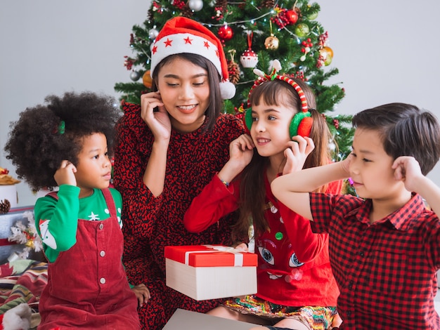 Foto buon natale e buone feste con persone internazionali, bambini che celebrano il natale in casa