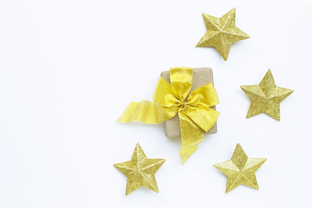 Buon natale e buone feste, composizione natalizia. confezione regalo con decorazioni a stella d'oro su sfondo bianco.