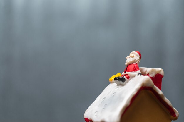 Merry Christmas and happy holidays! Cute Santa Claus sitting on the roof